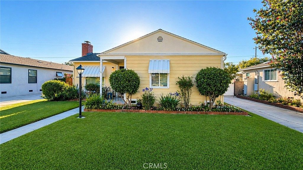 Front of the house from a side angle showing the awning detail and trimmed hedges