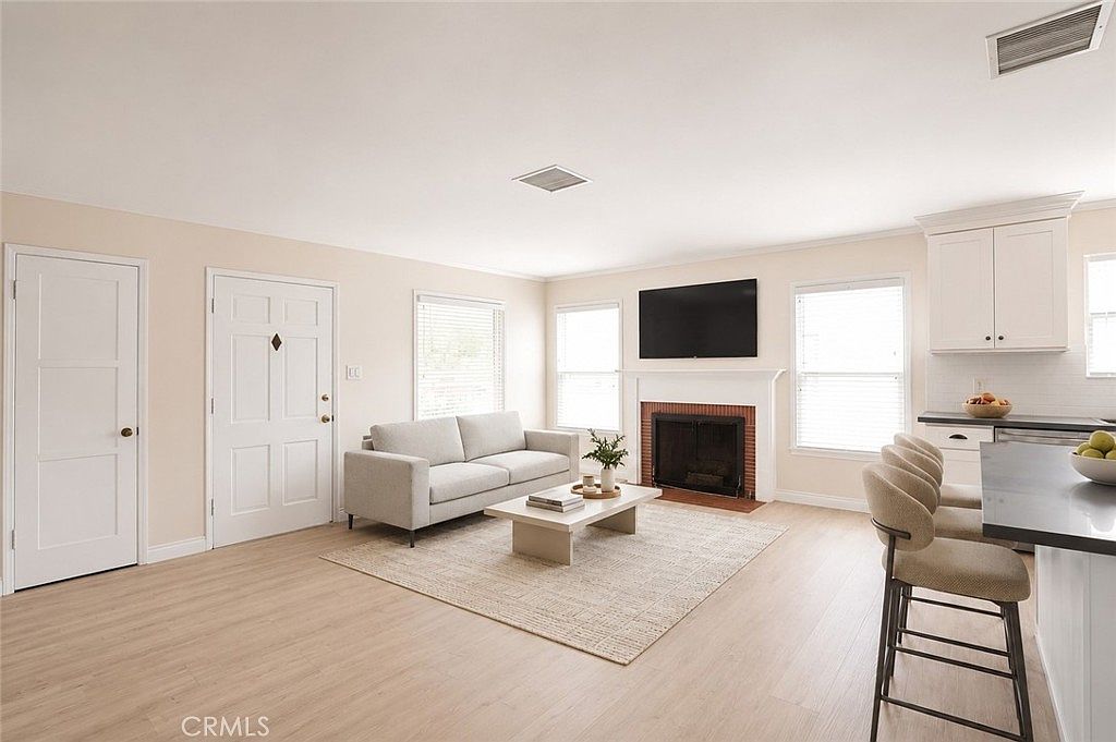 Sunlit living room with new fireplace and adjacent breakfast bar
