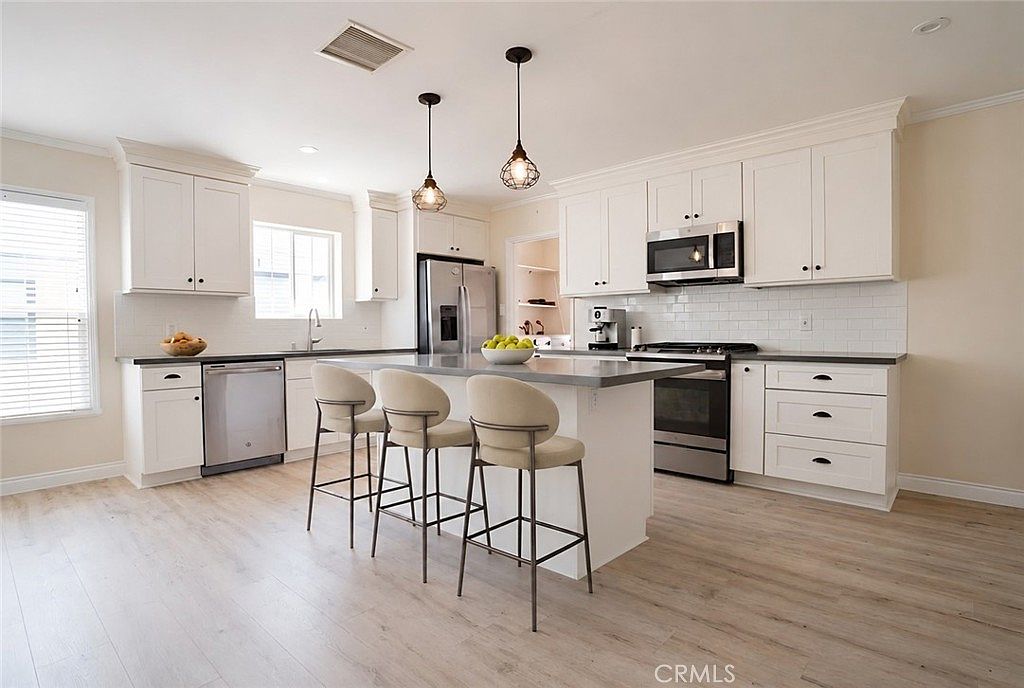 Remodeled kitchen with white shaker cabinets and stainless appliances